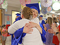  Kenmore West senior hugs staff member at Holmes Elementary during a graduation walk